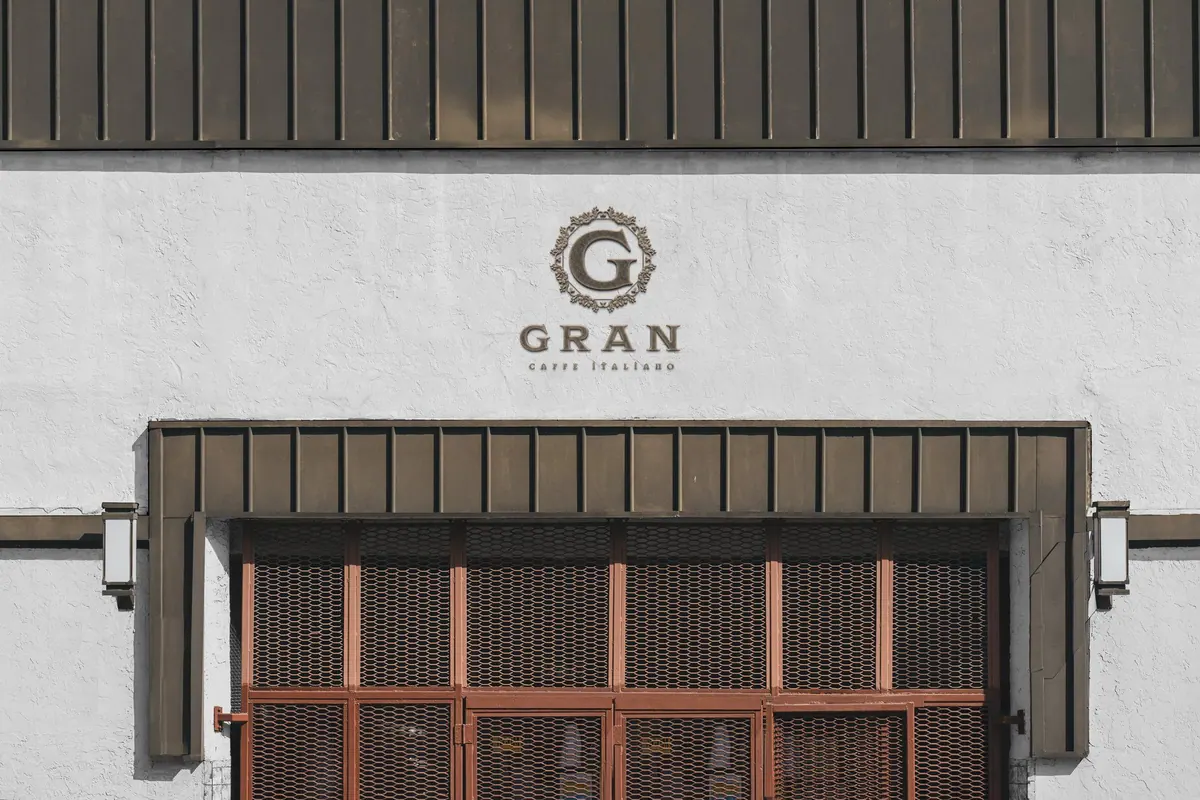 Πρόσοψη με το G μέσα σε λεπτό διακοσμητικό κύκλο πάνω από το GRAN Caffè Italiano